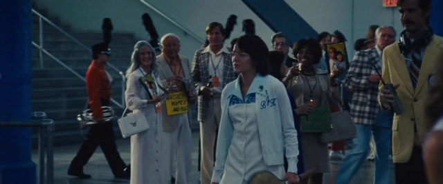 Wide shot frame from Battle of the Sexes — walking, dialogue, hat