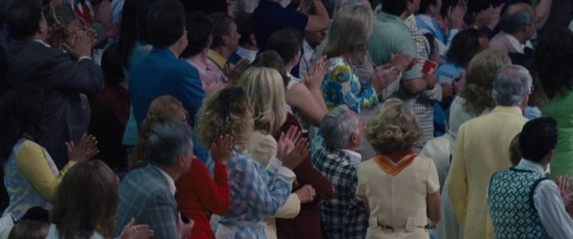 Wide shot frame from Battle of the Sexes — standing, belt, bracelet
