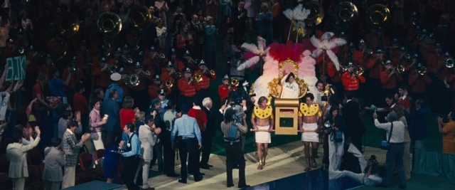 Wide shot frame from Battle of the Sexes — standing, suit, night