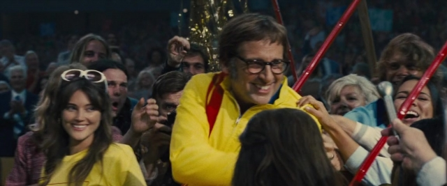 Wide shot frame from Battle of the Sexes — hand, person, human face