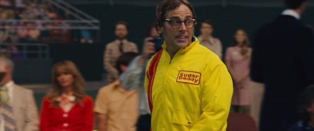 Wide shot frame from Battle of the Sexes — standing, room, tie