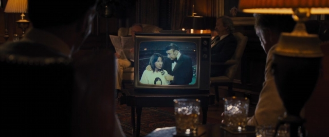 Frame from Battle of the Sexes — sitting, dialogue, suit