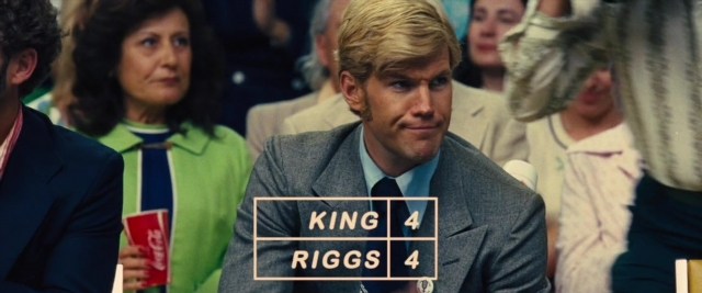 Wide shot frame from Battle of the Sexes — sitting, suit, tie