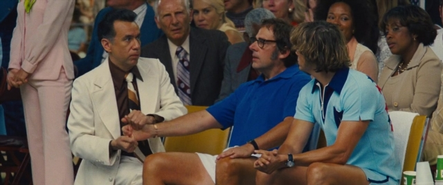Wide shot frame from Battle of the Sexes — sitting, room, table