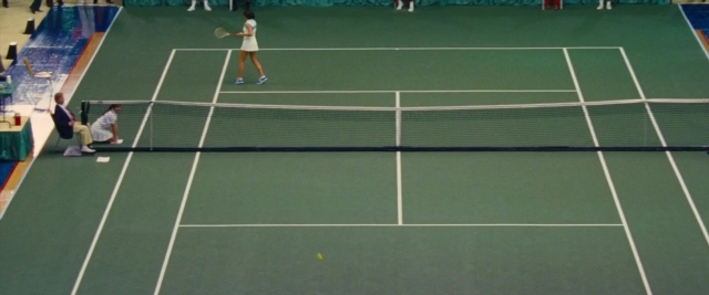 Wide shot frame from Battle of the Sexes — sitting, table, shirt