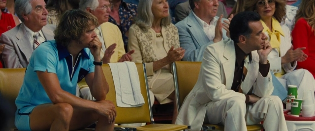 Medium shot frame from Battle of the Sexes — sitting, suit, dress