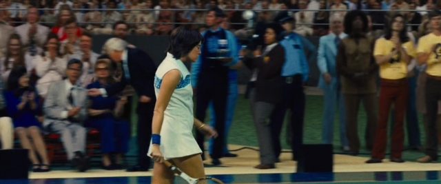 Wide shot frame from Battle of the Sexes — standing, hand, suit