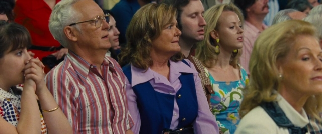 Wide shot frame from Battle of the Sexes — sitting, hand, shirt