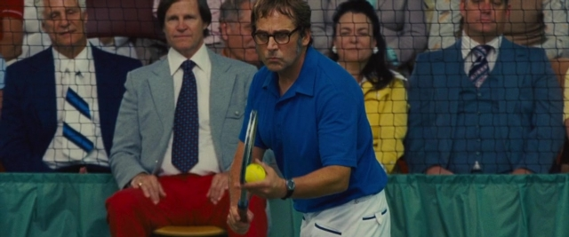 Wide shot frame from Battle of the Sexes — sitting, standing, watch