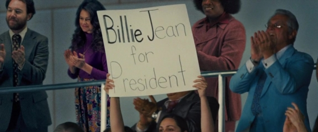 Wide shot frame from Battle of the Sexes — standing, suit, dress