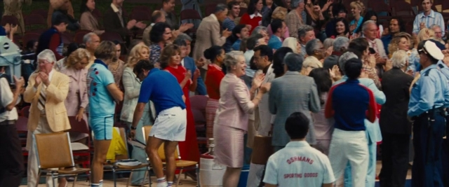 Wide shot frame from Battle of the Sexes — standing, shirt, person