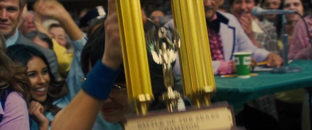 Wide shot frame from Battle of the Sexes — sitting, desk, table