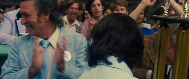 Wide shot frame from Battle of the Sexes — standing, room, dialogue