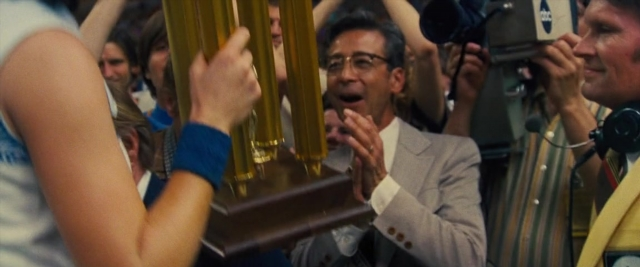 Wide shot frame from Battle of the Sexes — standing, room, dialogue