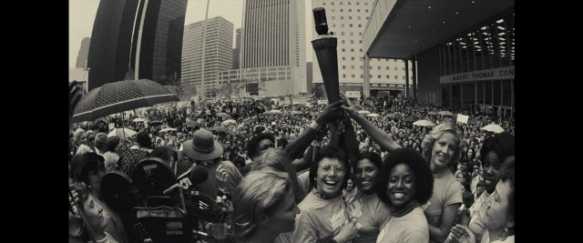 Wide shot frame from Battle of the Sexes — skyscraper, person, human face