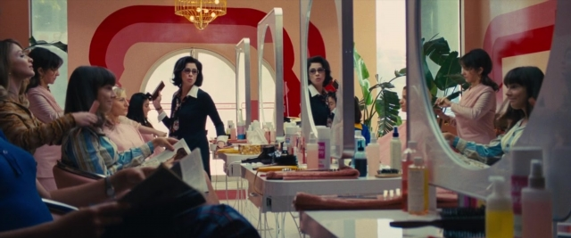 Wide shot frame from Battle of the Sexes — sitting, standing, room