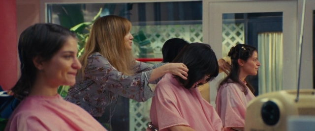 Wide shot frame from Battle of the Sexes — sitting, standing, room