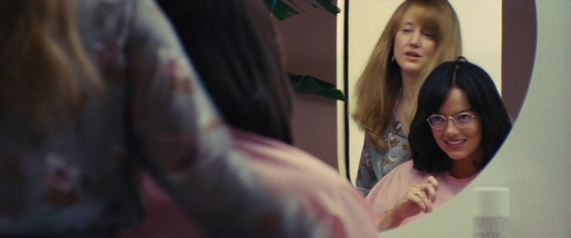 Wide shot frame from Battle of the Sexes — standing, mirror, shirt
