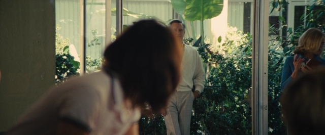 Wide shot frame from Battle of the Sexes — standing, room, phone