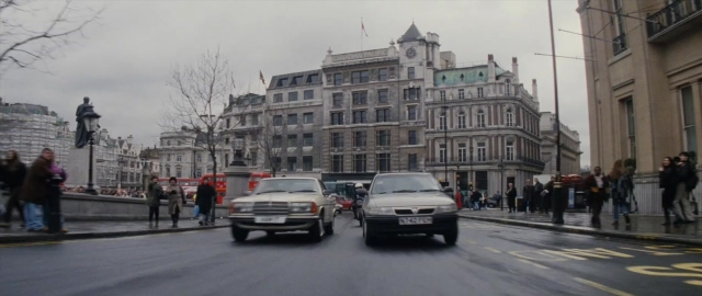 Wide shot frame from 101 Dalmatians — walking, street, car