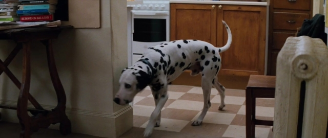 Wide shot frame from 101 Dalmatians — book, standing, table