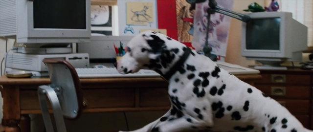 Wide shot frame from 101 Dalmatians — sitting, desk, room
