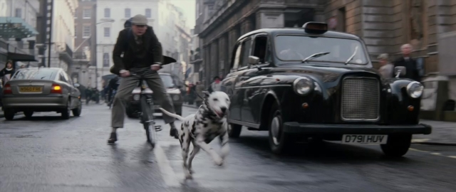 Wide shot frame from 101 Dalmatians — plate, street, hat