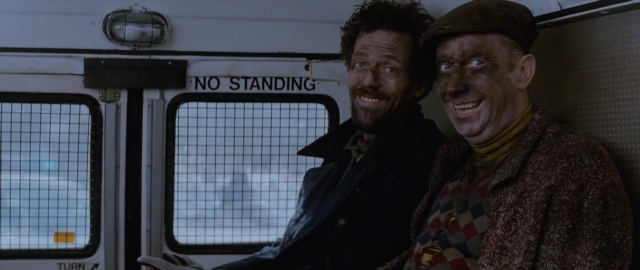 Wide shot frame from 101 Dalmatians — sitting, book, standing