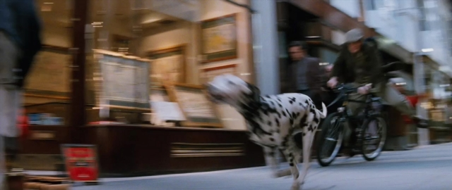 Wide shot frame from 101 Dalmatians — walking, street, dog