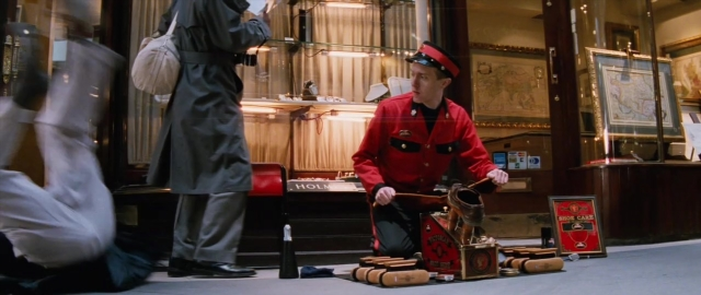 Wide shot frame from 101 Dalmatians — standing, room, hat