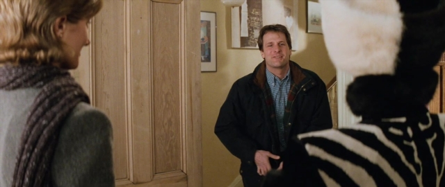 Wide shot frame from 101 Dalmatians — standing, dialogue, coat
