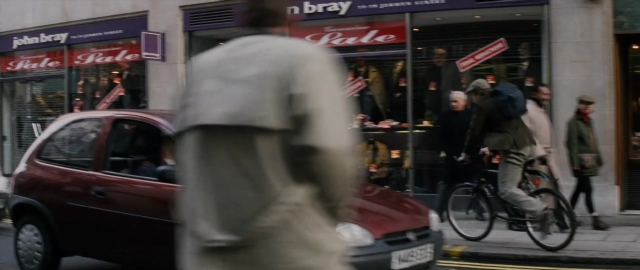 Wide shot frame from 101 Dalmatians — walking, street, car