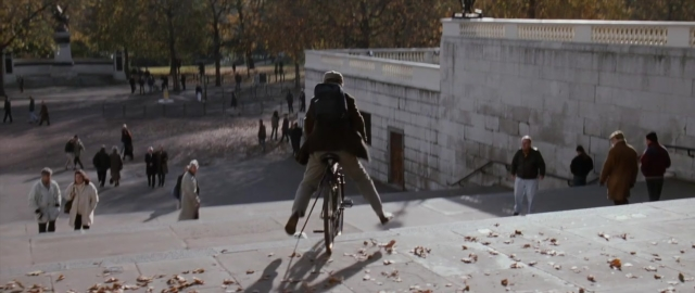 Wide shot frame from 101 Dalmatians — walking, bicycle, person