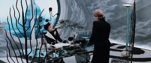 Wide shot frame from 101 Dalmatians — sitting, book, standing