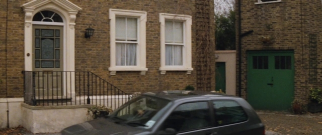 Wide shot frame from 101 Dalmatians — door, car, house