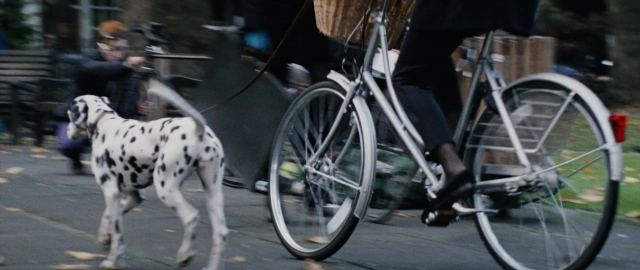 Wide shot frame from 101 Dalmatians — sitting, walking, street