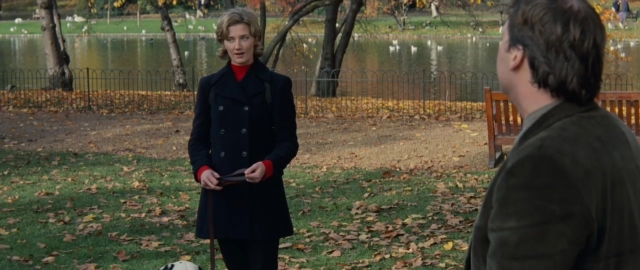 Wide shot frame from 101 Dalmatians — standing, coat, hand
