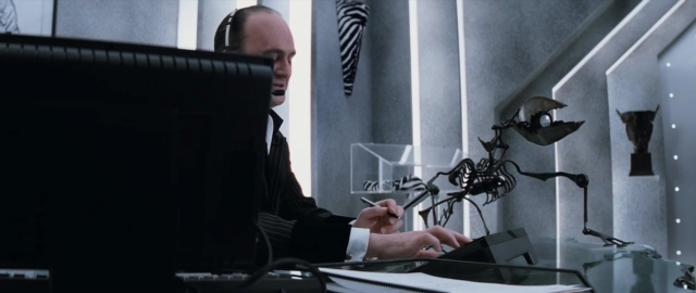 Medium shot frame from 101 Dalmatians — sitting, suit, tie