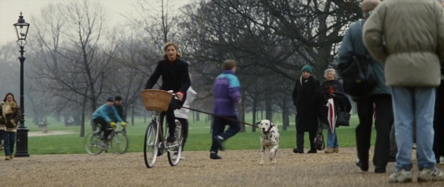 Wide shot frame from 101 Dalmatians — walking, dog, bicycle