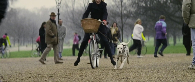 Wide shot frame from 101 Dalmatians — walking, hat, dog