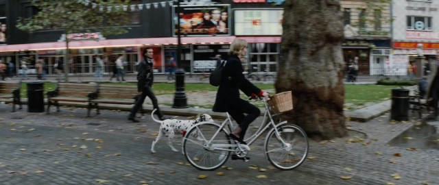 Wide shot frame from 101 Dalmatians — walking, street, dog