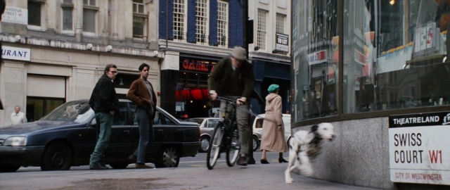 Wide shot frame from 101 Dalmatians — walking, hat, dog