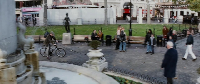 Wide shot frame from 101 Dalmatians — walking, street, bicycle
