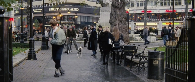 Wide shot frame from 101 Dalmatians — walking, street, person