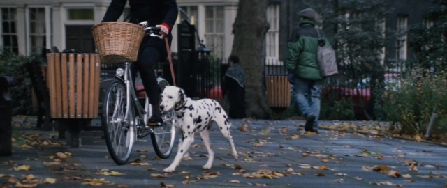 Wide shot frame from 101 Dalmatians — walking, street, dog
