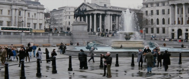 Wide shot frame from 101 Dalmatians — walking, street, clock