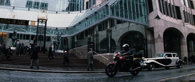 Wide shot frame from 101 Dalmatians — walking, street, hat