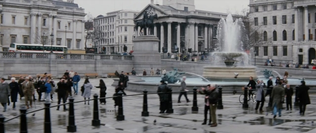 Wide shot frame from 101 Dalmatians — sitting, walking, street