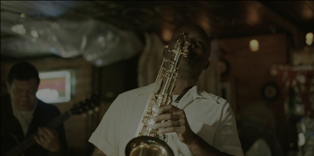 Wide shot frame from Green Book — room, shirt, clock