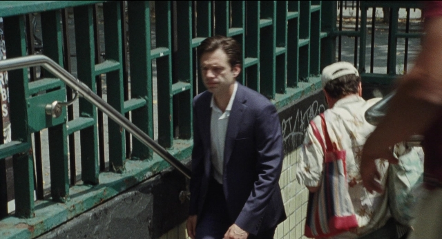 Wide shot frame from A Different Man — walking, suit, shirt
